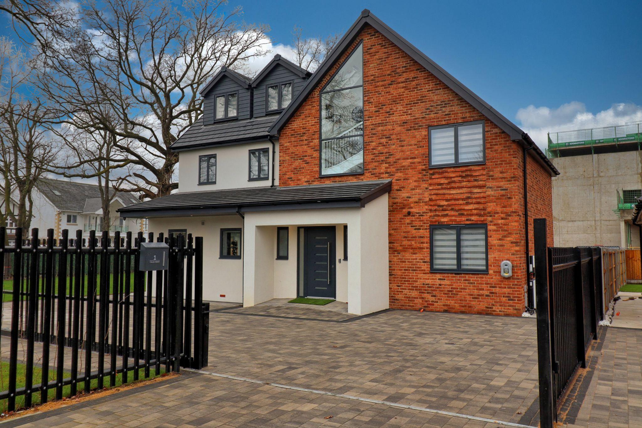 Detached home with brick, render and landscaped front