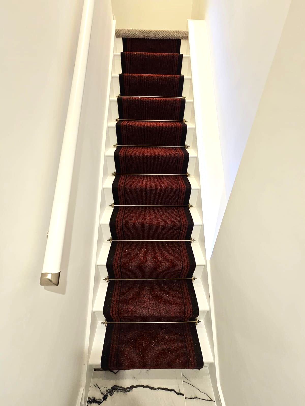 Renovated staircase with carpet runner and marble floor