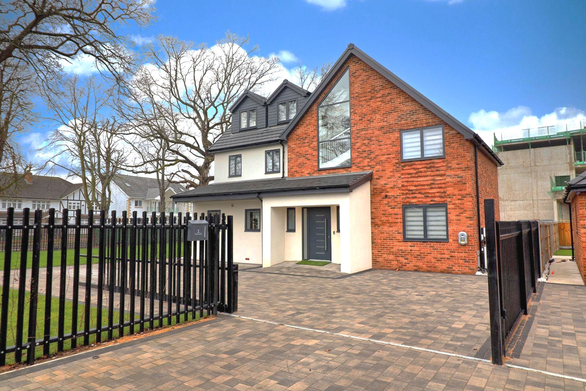 House with dormers, rendered facade and paved driveway